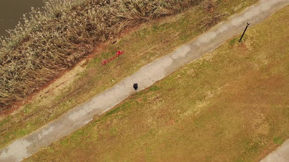 a bird's eye view over a guy walking along a paved walkway on a cloudy day in Flushing Meadows Coron alt