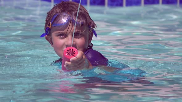 A boy plays in a pool at a hotel resort. alt