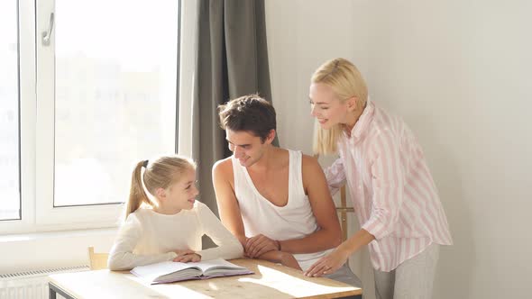 Father and Mother Help Their Daughter Do Their Homework