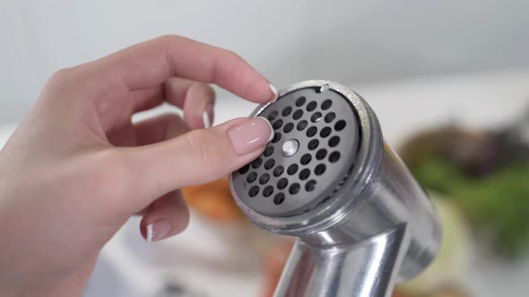 Female Hand Sets Cutting Plates in Meat Grinder for Providing Quality Mince From All Types of Meat alt