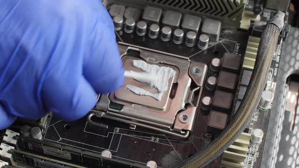 Electronics technician lubricates the computer processor on the motherboard