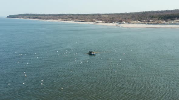 AERIAL: Fishermans Catching Fish Near the Shore in Klaipeda on a Sunny Day alt
