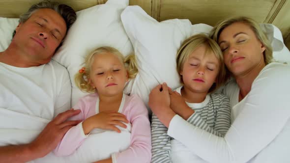 Family sleeping on bed in the bed room 4k alt
