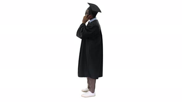 Smiling African American Male Student in Graduation Robe Talking on the Phone Sharing Happy News alt