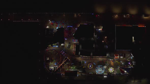 AERIAL: Breathtaking Birds View on Santa Monica Pier at Night with Ferris Wheel and Colorful Lights alt