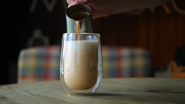 Barista Pours Milk Into a Coffee Glass for Latte