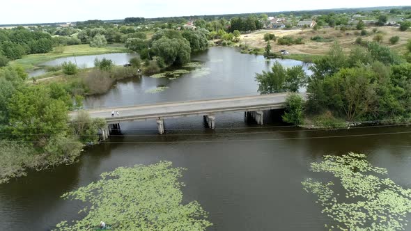 Aerial view of a picturesque river in the countryside with masonry and a concrete bridge