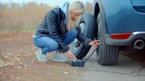 Checking Tire Pressure. Pumping Air Into Auto Wheel. Electric Pump Inflates Pressure Gauge For Car. alt