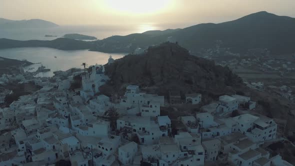Drone footage of Chora town with churches on the hill at sunset, Ios Greek island in Greece