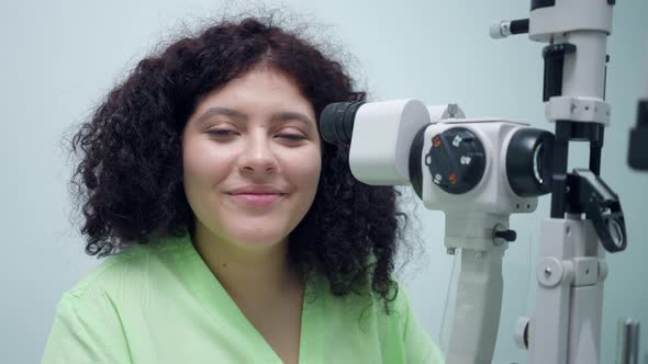Portrait of Confident Positive Woman Sitting at Retina Camera in Ophthalmologic Clinic Smiling alt