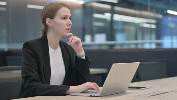 Businesswoman Thinking While Using Laptop at Work alt