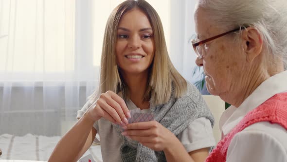 Female Caregiver and Senior Woman Playing Cards at Home