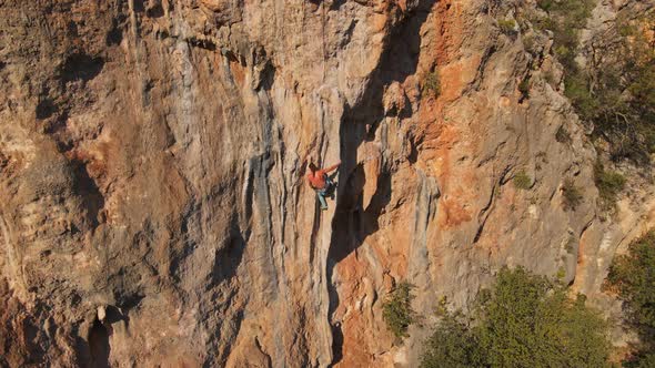 Aerial Point of View From Drone of Strong Muscular Man Climbs on Big Rock Tufa on Challenging Rock alt