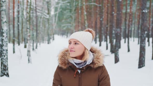 Pretty Woman in Winter Walking in the Forest and Admiring the Nature