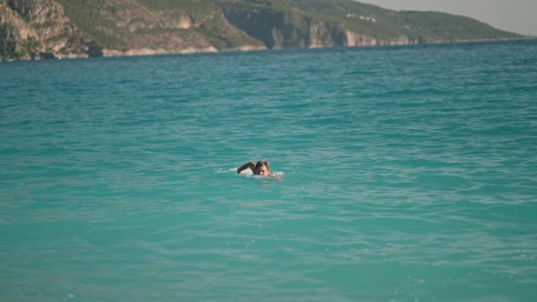 Strong Athletic Man Swims in Turquoise Water of Mediterranean Sea in Oludeniz Beach in Aegean Sea alt