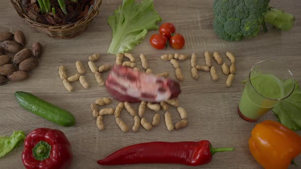Raw Meat Falling in Slow Motion on Table with Nuts and Vegetables alt