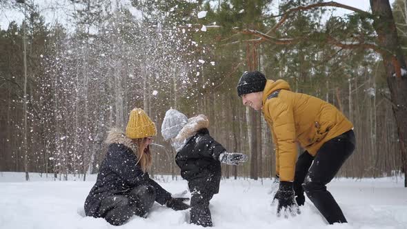 Mom and Dad are Throwing a Snow Making a Snowfall for Their Son in Slow Motion alt