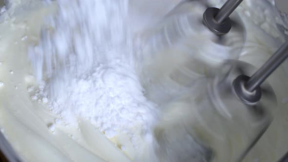 The woman chef whips the ingredients for baking with a mixer. Whipped cream with a mixer alt