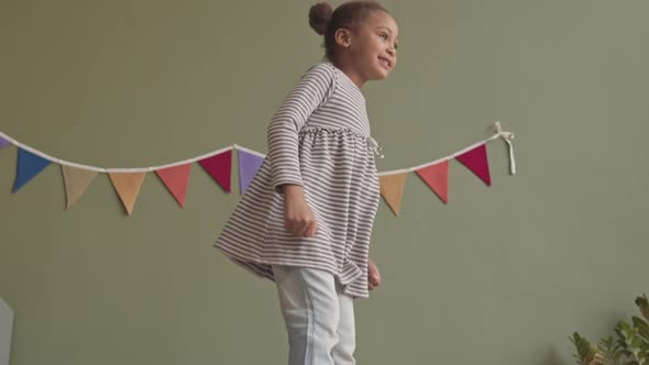 Cheerful Girl Jumping on Bed alt