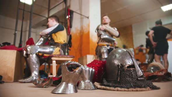 Men in the Dressing Room Taking Off the Armour alt