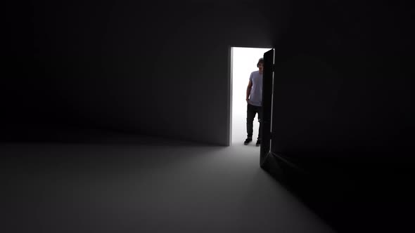 Opening the door in the dark, rays of light penetrate inside, a man is standing.