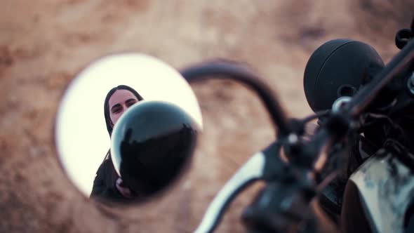 Reflection in Rear View Mirror, Beautiful Female Biker Putting on Helmet.