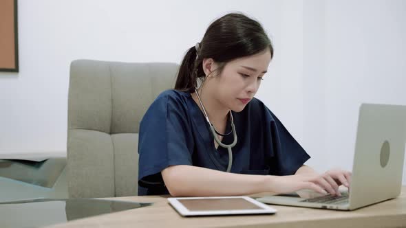 young Asian doctor walks into a office where she is stressed out of being a surgeon
