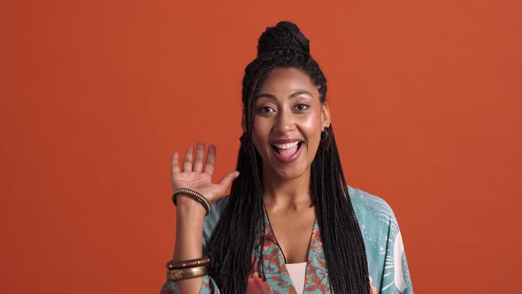 A friendly african american woman doing goodbye gesture alt