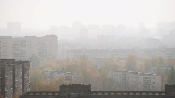 Aerial View of Roofs of Buildings in Urban Area in Fog on Autumn Day alt