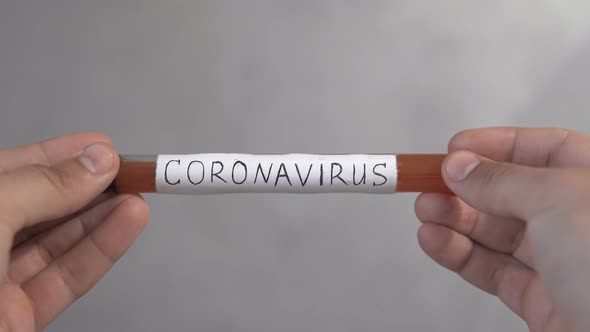 A doctor holds a test tube with a covid-19 test vaccine in his hand. alt