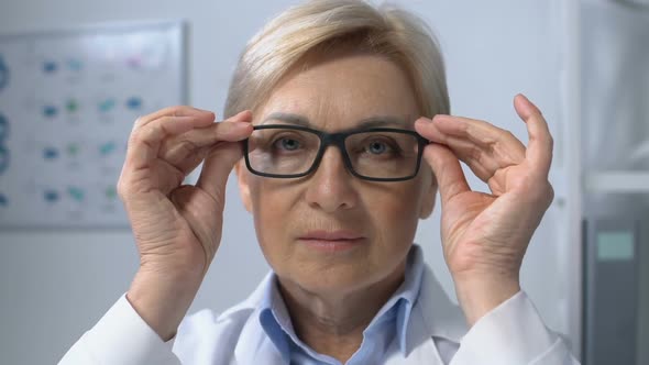 Lady Therapist Adjusting Eyeglasses and Looking to Camera, Experienced Worker