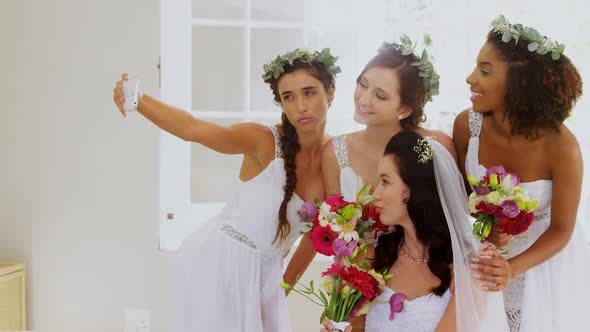 Bride and bridesmaid taking a selfie alt