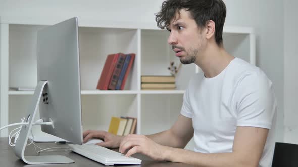 Shocked Creative Man Wondering and Working on Desktop alt