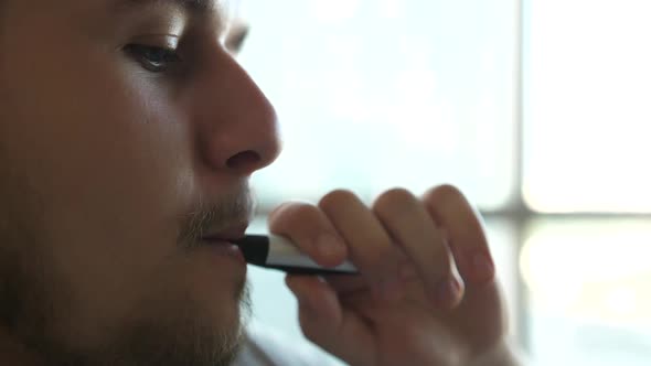 Closeup of Man Inhaling an Ecigarette Vaping Device