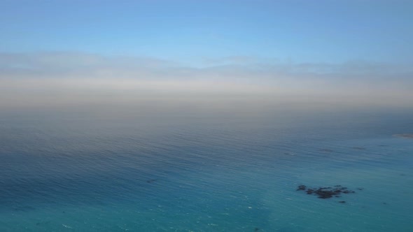 Aerial shot of the calm ocean turning into the blue sky in Malibu, California, USA alt