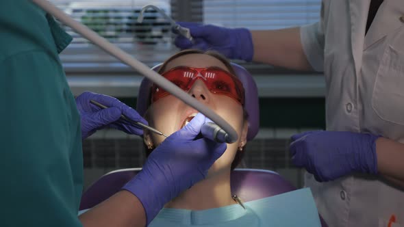 Dentist Is Taking Care About Patient's Tooth Using Electric Dental Brush. Woman's Portrait in Dental alt