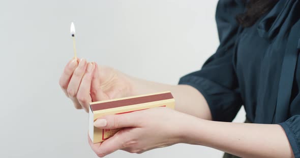 Hands lighting a match alt