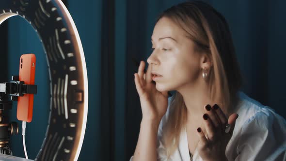 Pretty Female Beauty Blogger Applies Makeup in Front of Ring Light Online
