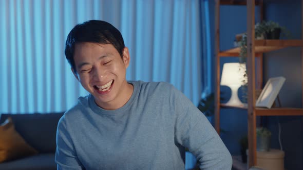 Asia businessman looking at camera having fun laugh smile relax video call meeting with friend. alt