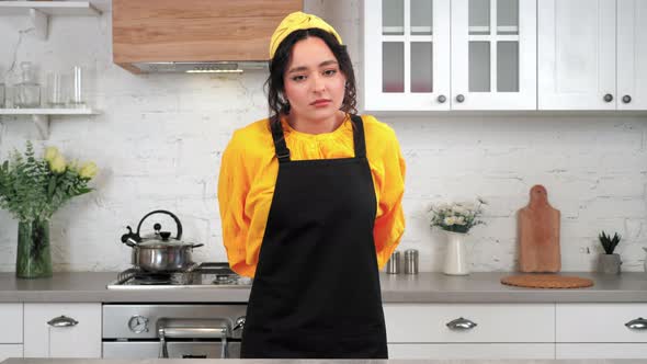 Portrait Tired Woman in Home Kitchen Takes Off Black Apron After Cooking Food alt