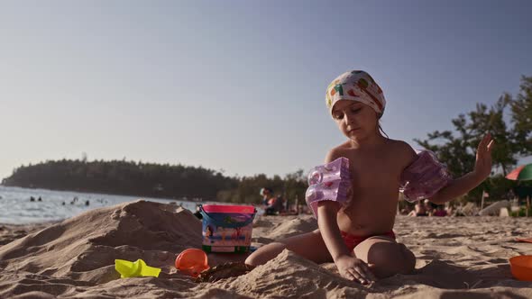 Beautiful Little Girl Playing in Sand On Tropical Beach alt