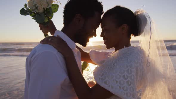 African american couple in love getting married, looking at each other on the beach at sunset alt