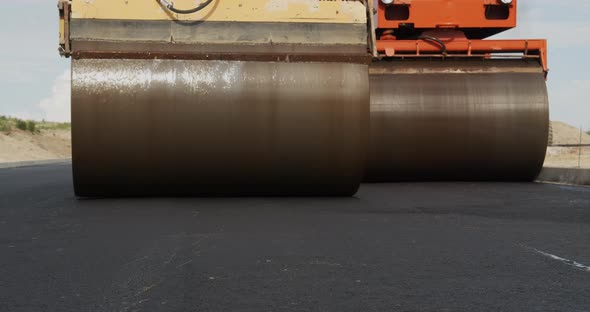 Two Yellow Pavers Ride And Flatten The Hot Asphalt. Steam In Road alt