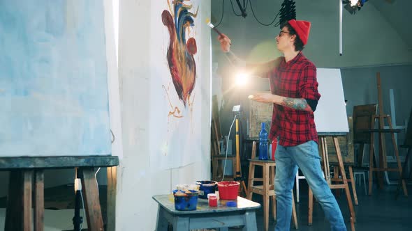 Art Studio with a Young Man Painting on a Massive Canvas alt