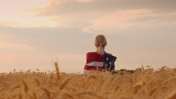 Farmer with Usa Flag on His Shoulders Stands in a Vast Field of Ripe Wheat alt