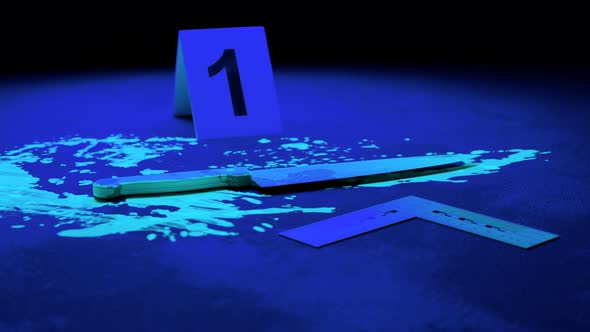 Crime scene investigation. Knife blood splats and markers in the ultraviolet. alt