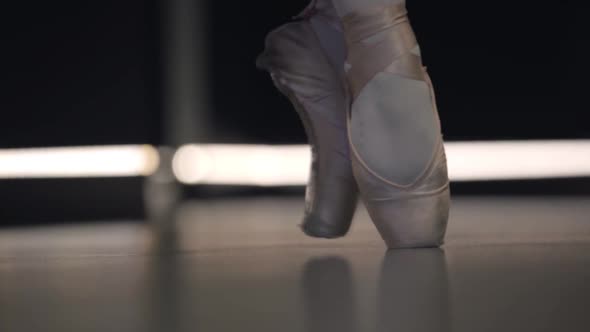 Close-up of Ballerina's Feet in Pointes Balancing on Tiptoes. Professional Female Ballet Dancer alt