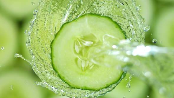 Super Slow Motion Shot of Splashing Water on Rotating Cucumber Slice at 1000Fps alt