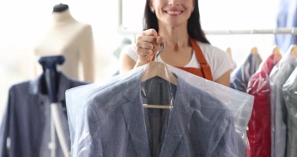 Woman Giving Out to Client Clean Clothes in Plastic Bags in Laundry  Movie alt