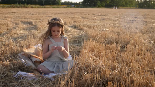 Serious Sad Girl a Child Sit on a Wheat Mown Field alt